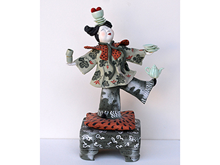 Woman balancing plates and teapots by Vicky Chock